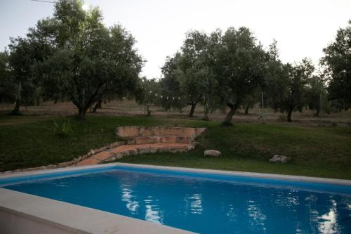 una piscina en un patio con árboles en Cortijo Botánico el Cerro, en Cabra
