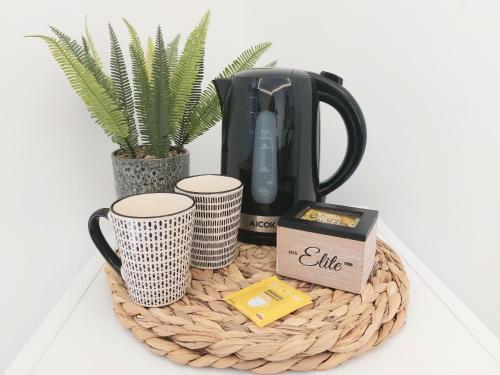 uma cesta com uma cafeteira, canecas e uma planta em La Gardenia em Celano