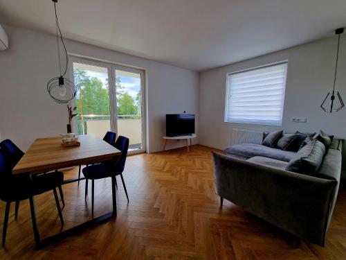 a living room with a couch and a table at Piękny apartament położony w środku lasu in Dywity