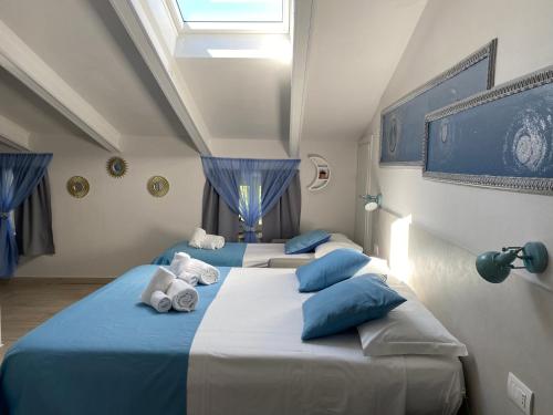 a room with three beds with blue and white pillows at B&B La Terrazza in Pozzolengo