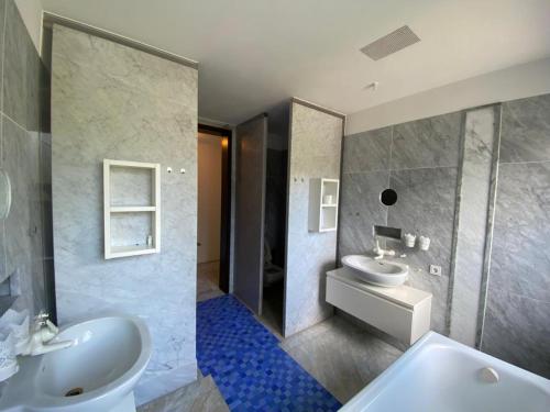 La salle de bains est pourvue de 2 lavabos et d'un miroir. dans l'établissement Villa Arche 2, à Neuenkirchen-Vörden