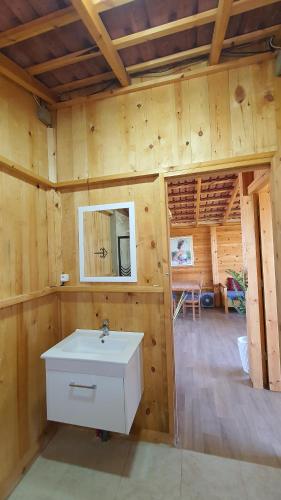 - une salle de bains avec lavabo dans une maison en bois dans l'établissement Chalet Jaune Diar Mammoura, à Nabeul