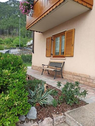 a bench sitting in front of a house at Appartamento Emma in Molveno