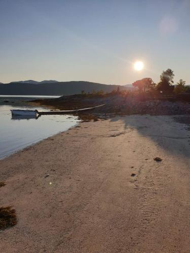 a boat sitting on the shore of a beach at Off-the-grid cabin on the island of Senja in northern Norway in Vangsvik