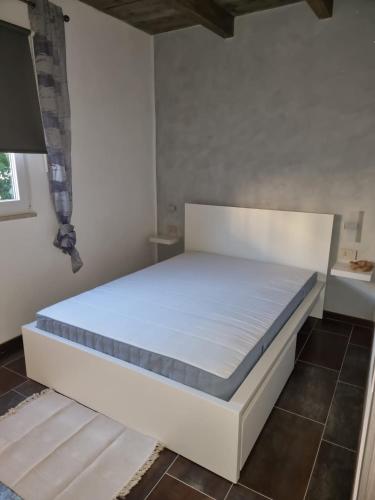 a bed in a room with a white mattress at Casa Elena in San Felice Circeo