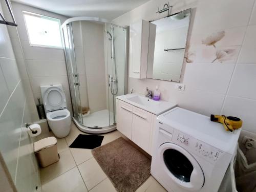 a bathroom with a washing machine and a toilet at Sea - View in Himare
