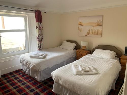 a bedroom with two beds with towels on them at Cutty Sark Inn in Eyemouth