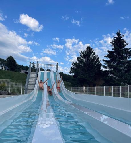 - un groupe de personnes sur un toboggan dans un parc aquatique dans l'établissement Le refuge des Gentianes, à Besse-et-Saint-Anastaise