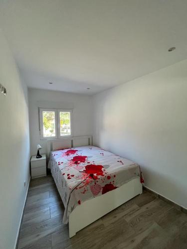 a bedroom with a bed with red flowers on it at De la Cuenca Mieres II con parking Privado in Mieres