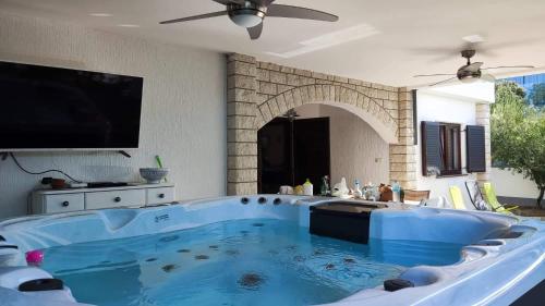 una gran bañera azul en la sala de estar con TV en Villa Pagar - with jacuzzi - Renovated in 2022 en Povljana