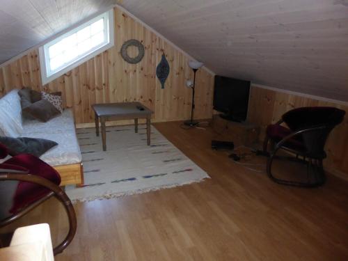 uma sala de estar com um sofá e uma televisão em Ny hytte i flott turterreng 