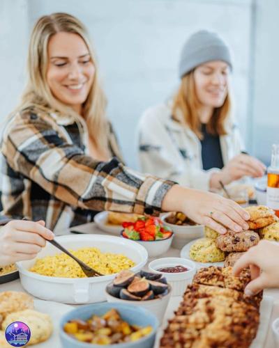 a group of people sitting at a table with food at Chalet Flodhaus- Bord Rivière St-Maurice (navigable) / SPA /SAUNA - Chalets Galaxia in Saint Roch de Mekinac