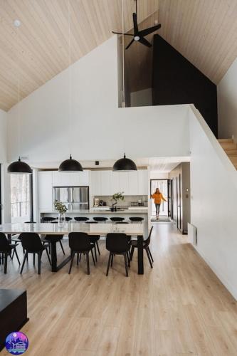 a dining room and kitchen with a table and chairs at Chalet Flodhaus- Bord Rivière St-Maurice (navigable) / SPA /SAUNA - Chalets Galaxia in Saint Roch de Mekinac