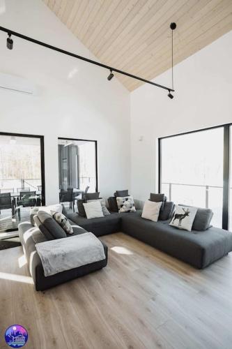 a living room with two couches in a room at Chalet Flodhaus- Bord Rivière St-Maurice (navigable) / SPA /SAUNA - Chalets Galaxia in Saint Roch de Mekinac