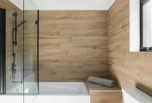 a bathroom with a tub and a glass shower at Chalet Flodhaus- Bord Rivière St-Maurice (navigable) / SPA /SAUNA - Chalets Galaxia in Saint Roch de Mekinac