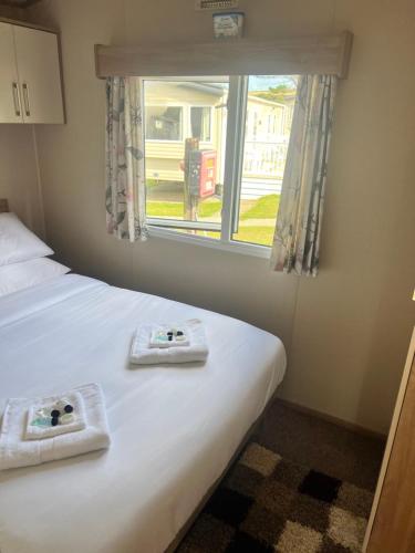 a bedroom with a bed with two towels on it at Oakley Newquay Bay Resorts in Newquay Bay Resort