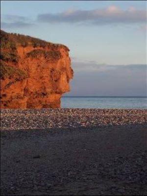 a rocky beach with a large cliff next to the ocean at Roxbury 5 Star 6 berth Luxury Caravan in Exeter