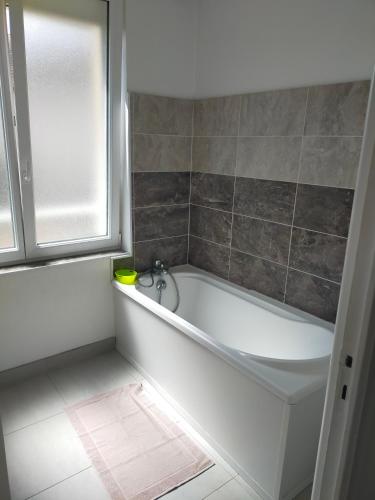 a white bath tub in a bathroom with a window at Bel Appartement 3 étoiles 7 pers 3 pièces 60m2 idéalement placé in Cabourg