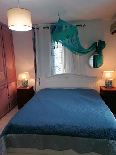 a bedroom with a blue bed and a window at Villa Tourelle of Paradise with bigPrivate Pool in Rivière Noire