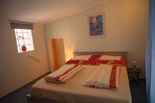 una camera da letto con un letto con due coperte sopra di Apartmani Mura a Mursko Središće
