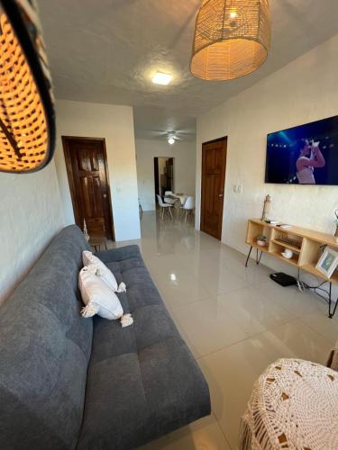 a living room with a couch and a tv at Hermoso condominio con alberca y club de playa!! in Manzanillo