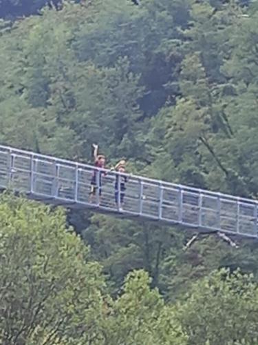 two people standing on a bridge in the trees at BnB Villa Melany vicino Centro in Lucca