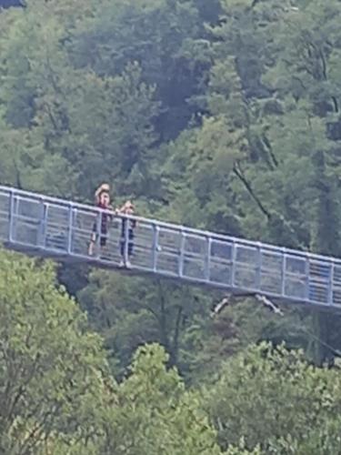 two people standing on a bridge in the forest at BnB Villa Melany vicino Centro in Lucca