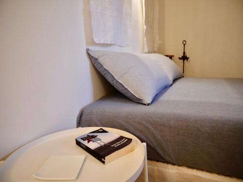 a book on a table next to a bed at Il Ciclope - La camera sotto il faro in Termoli
