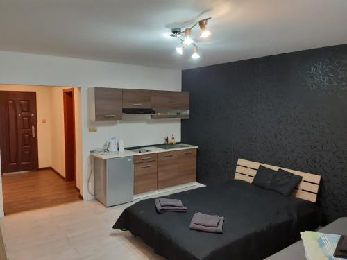 a bedroom with a bed and a small kitchen at APARTMÁNY Fortuna in Vysoké Tatry