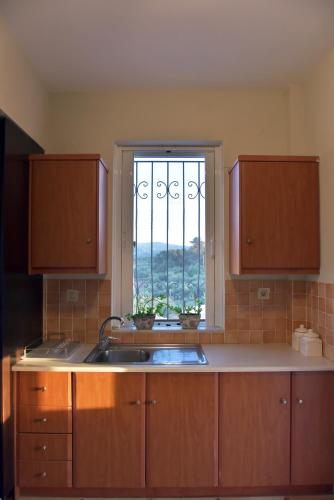 a kitchen with a sink and a window at VILLA BLUE VEDERE in Gerani