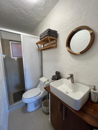 La salle de bains est pourvue de toilettes, d'un lavabo et d'un miroir. dans l'établissement Hermoso condominio con alberca y club de playa!!, à Manzanillo