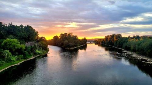 una vista de un río con la puesta de sol en el fondo en Guesthouse ob Sotočju Budič en Brežice