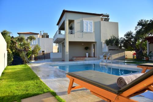 a swimming pool in front of a house at VILLA BLUE VEDERE in Gerani