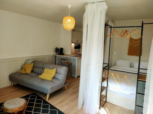 a living room with a couch and a bed at Agréable studio de l'Arsault avec parking in Périgueux