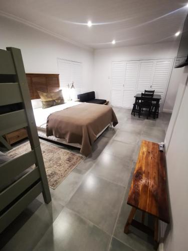 a bedroom with a bed and a wooden table at 10 Jock Meiring Guesthouse Unit 3 in Bloemfontein