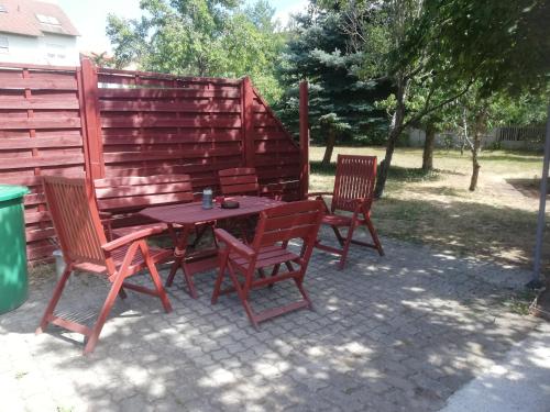 a picnic table with three chairs next to a fence at Ochsenhof in Feuchtwangen