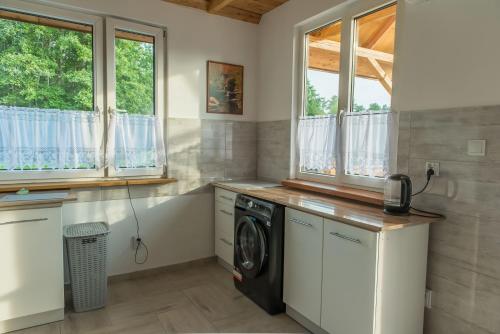 a laundry room with a washer and dryer at Domki Snopki in Pisz