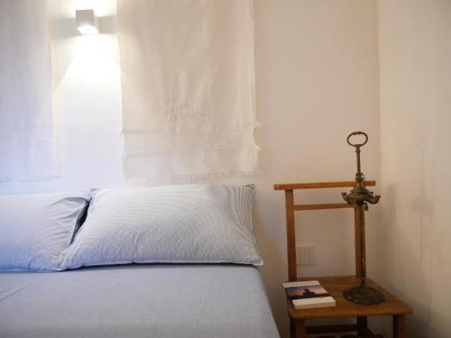 una camera da letto con un letto con un cuscino bianco e un tavolo di Il Ciclope - La camera sotto il faro a Termoli