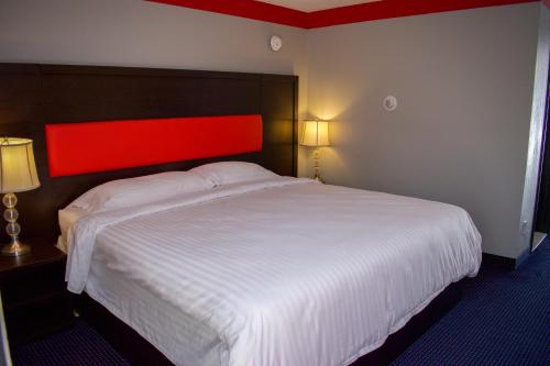 a bedroom with a large white bed with a red headboard at Travel inn in North Kingstown