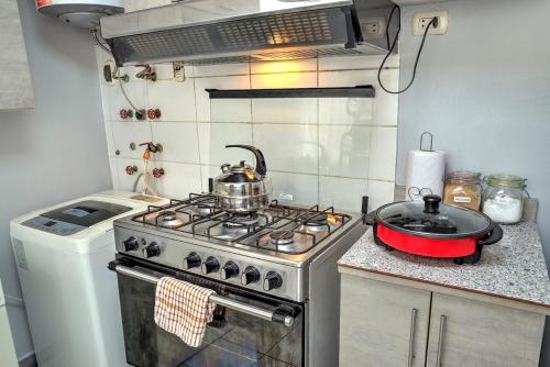 a kitchen with a stove with a pot on it at Dpto entero, 2do piso, ascensor, jacuzzi y cochera in Lima