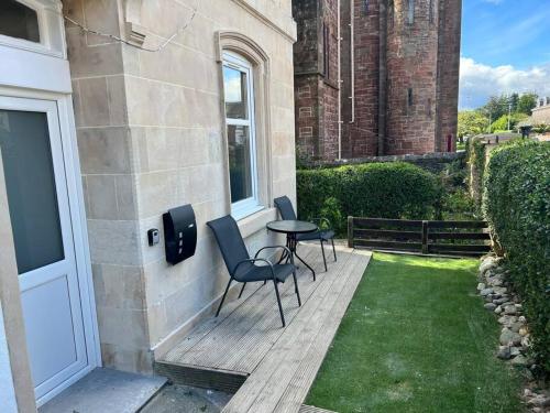a patio with two chairs and a table on a house at Central Helensburgh 1 BR, gr floor pet friendly in Helensburgh