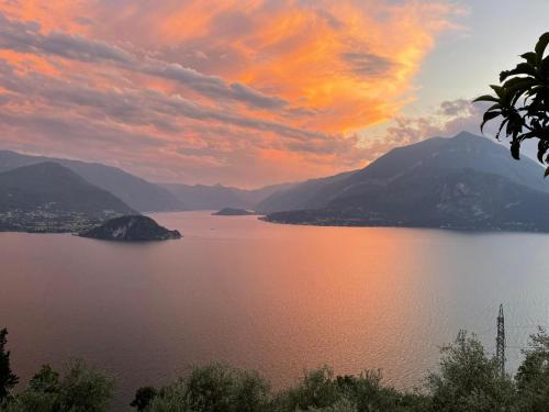 a sunset over a body of water with mountains at Casa Caravino in Varenna
