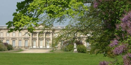 a large building with a green lawn in front of it at gîte Cosy Green 2 in Chevincourt