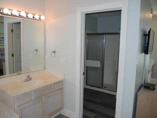 a bathroom with a sink and a shower with a mirror at 503 villa in Calabash