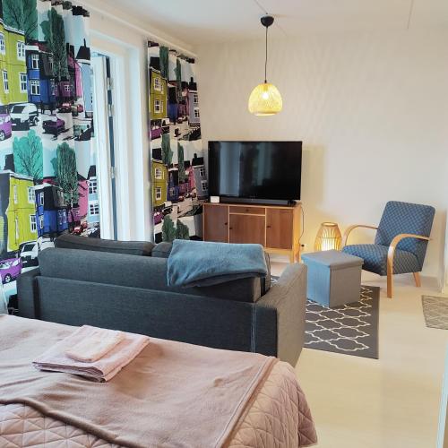 ein Wohnzimmer mit einem Sofa und einem Flachbild-TV in der Unterkunft Lovely new city apartment all amenities in Seinäjoki