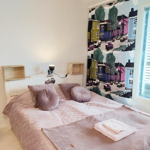 una camera da letto con un letto con cuscini sopra di Lovely new city apartment all amenities a Seinäjoki