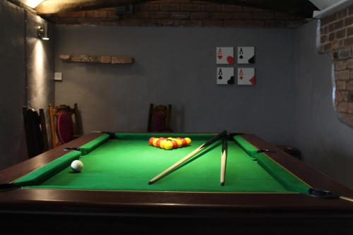 a pool table with two cuesticks and balls on it at West View Cottage in Worcester