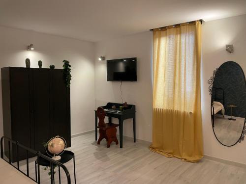 un soggiorno con specchio, cassettiera e TV di Arco di Levante alle Colonne a Bari