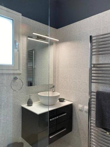 a bathroom with a sink and a glass shower at Villa Alexakis Doukades in Doukádes