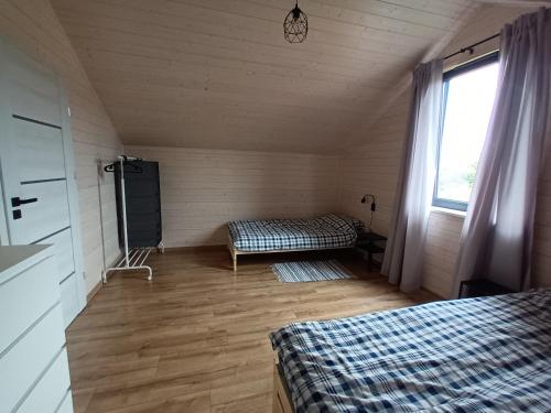 a room with two beds and a window at Zakątek na Ptasiej in Sasino